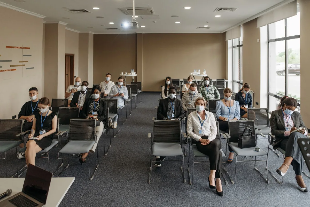Pessoas com máscaras em reunião de negócios com distanciamento social. — Medicina Ocupacional Curitiba