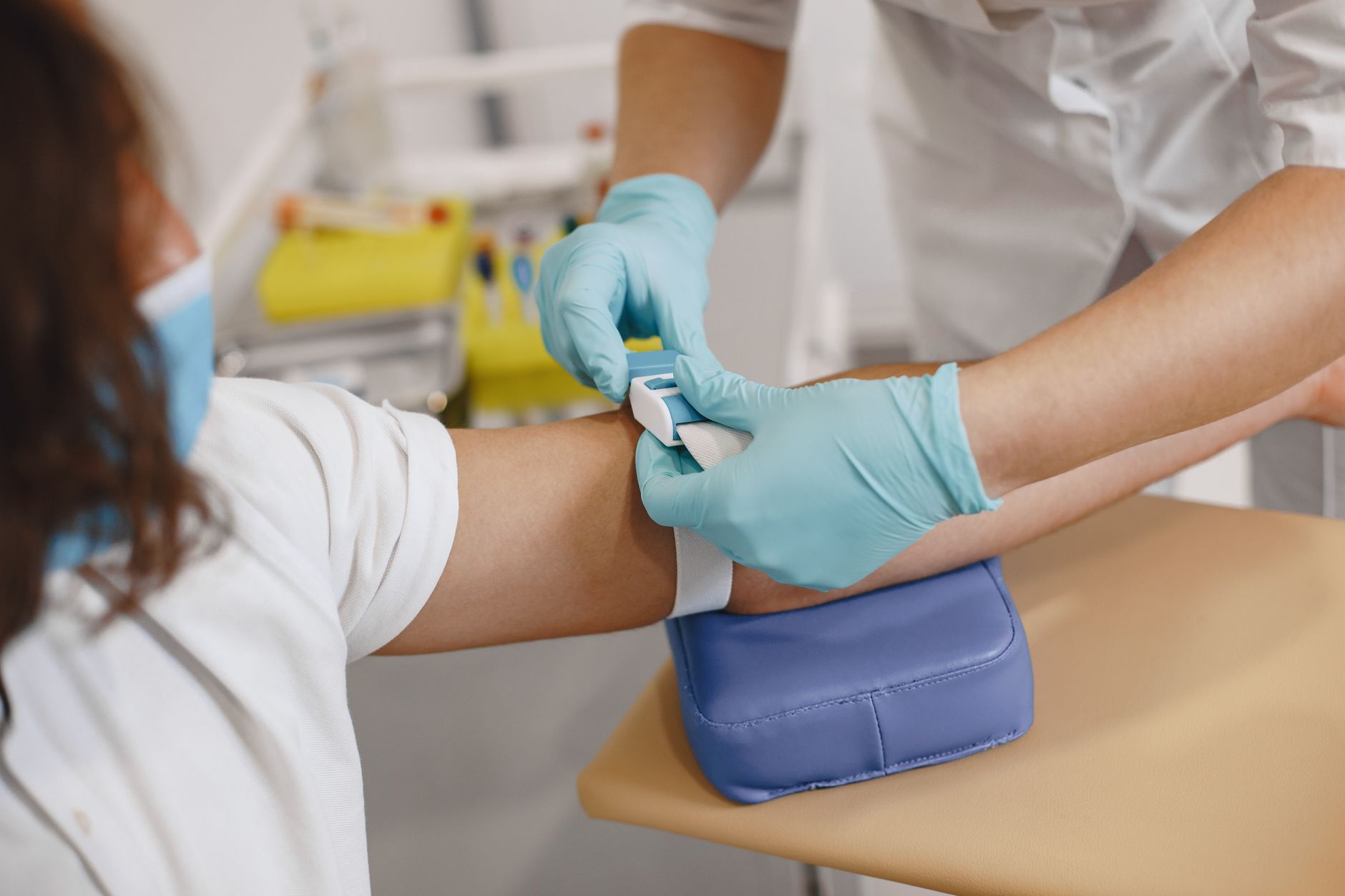 Homem em jaleco branco realiza exame médico em funcionário em sala de hospital. — Medicina Ocupacional Curitiba
