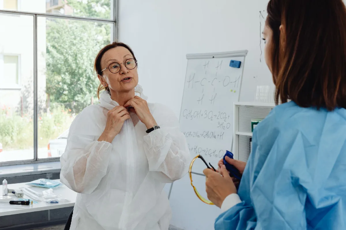 Ficha de EPI em Curitiba: Gestão Documental Técnica Profissionais de saúde em EPI discutem informações em um laboratório claro. — Medicina Ocupacional Curitiba
