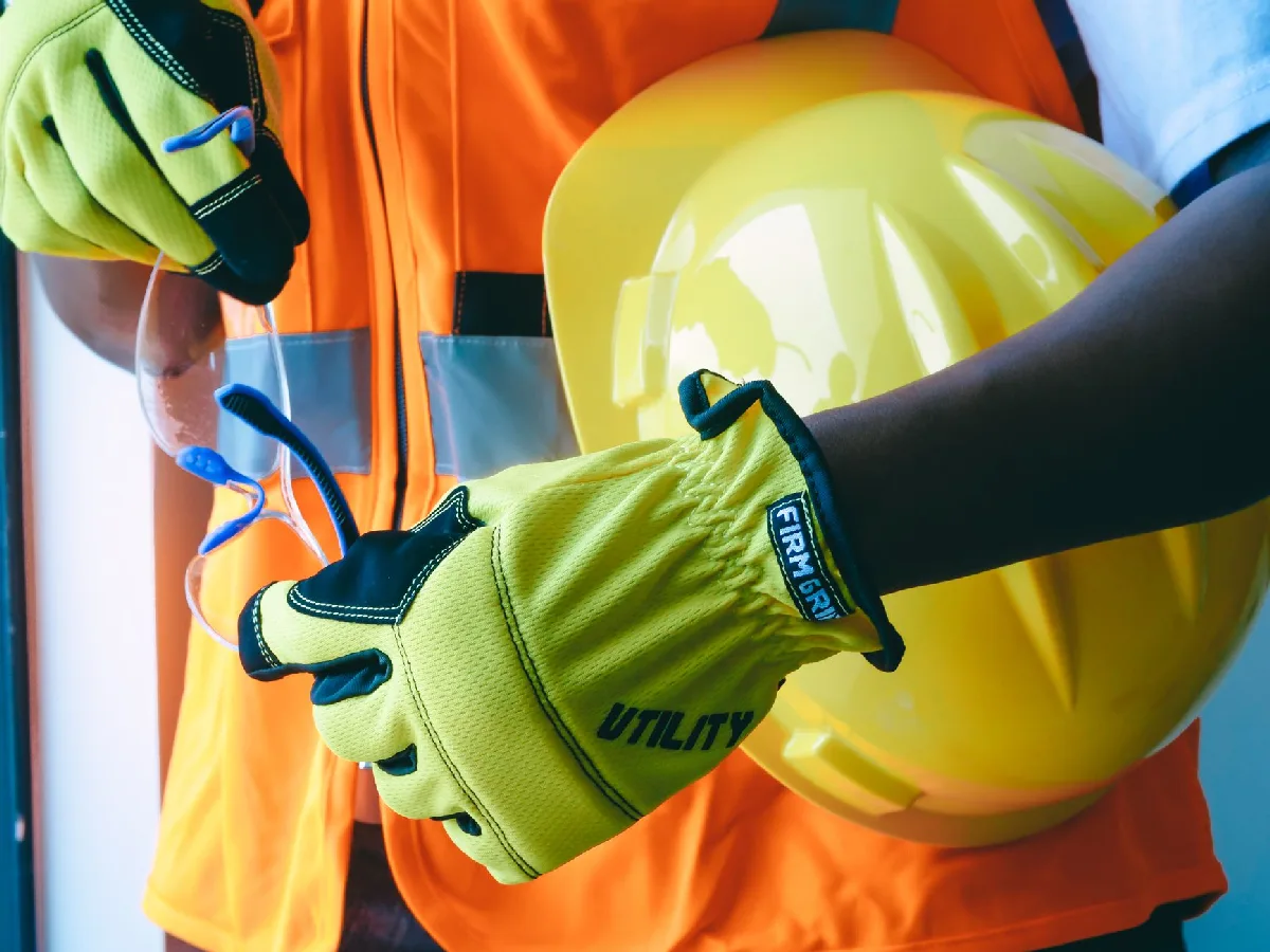 Ficha de EPI: prazos, NRs e responsabilidades em Curitiba Luvas e capacete de equipamento de proteção individual em close-up. — Medicina Ocupacional Curitiba
