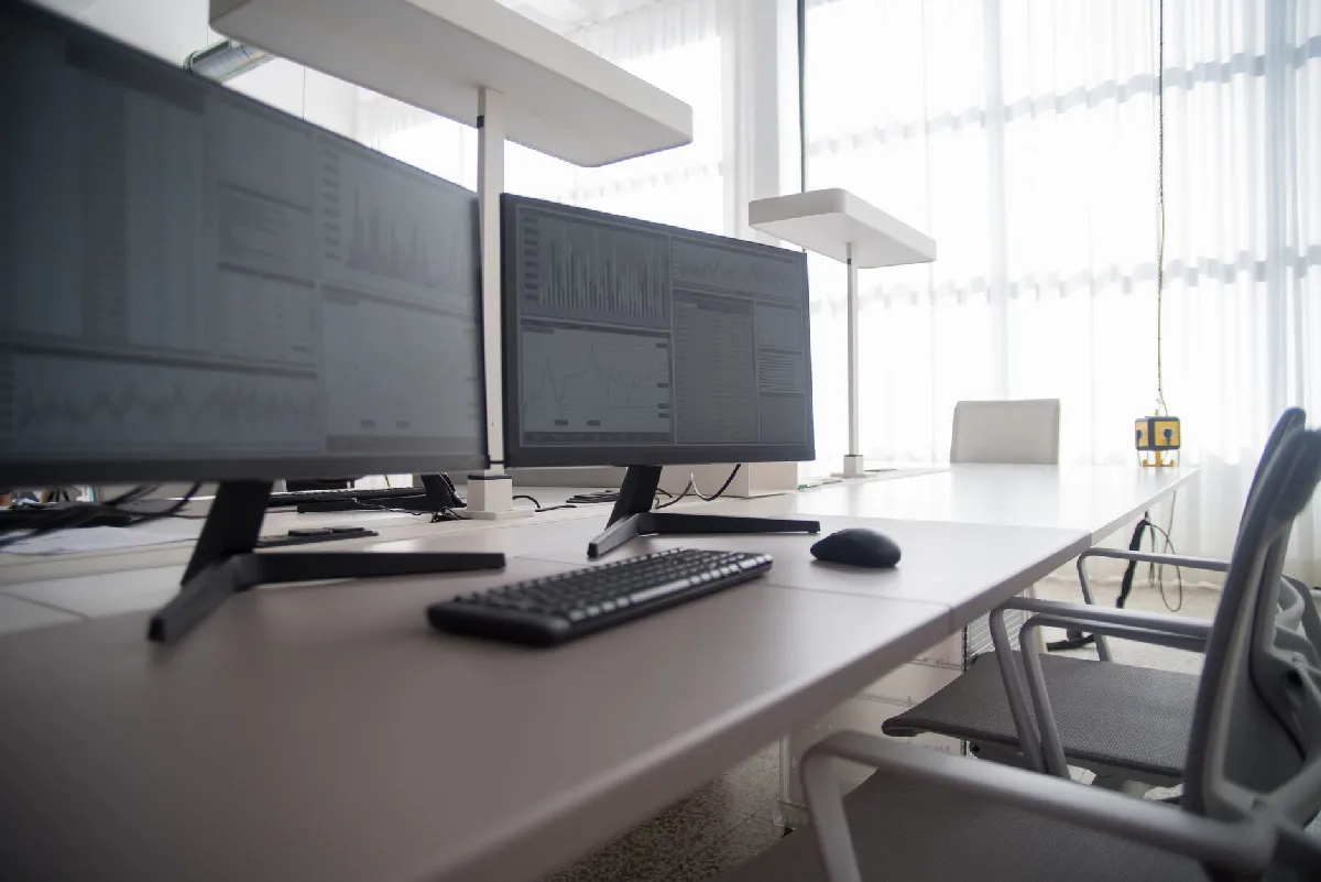 Laudo Ergonômico NR-17 em Curitiba: Protocolo e Falhas Comuns Escritório moderno com monitores de computador e cadeiras ergonômicas. — Medicina Ocupacional Curitiba
