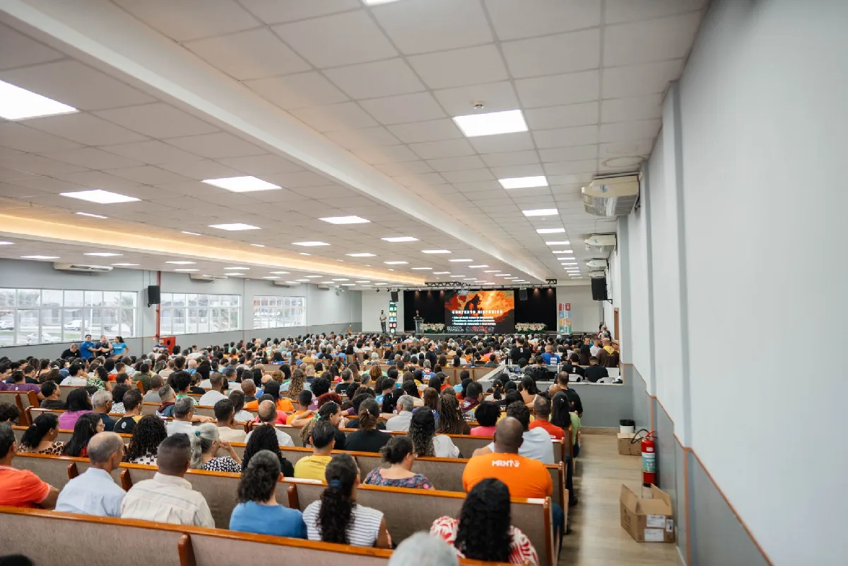 Organização de SIPAT em Curitiba: Protocolo e Conformidade Plateia em auditório espaçoso assiste a apresentação com palco visível. — Medicina Ocupacional Curitiba
