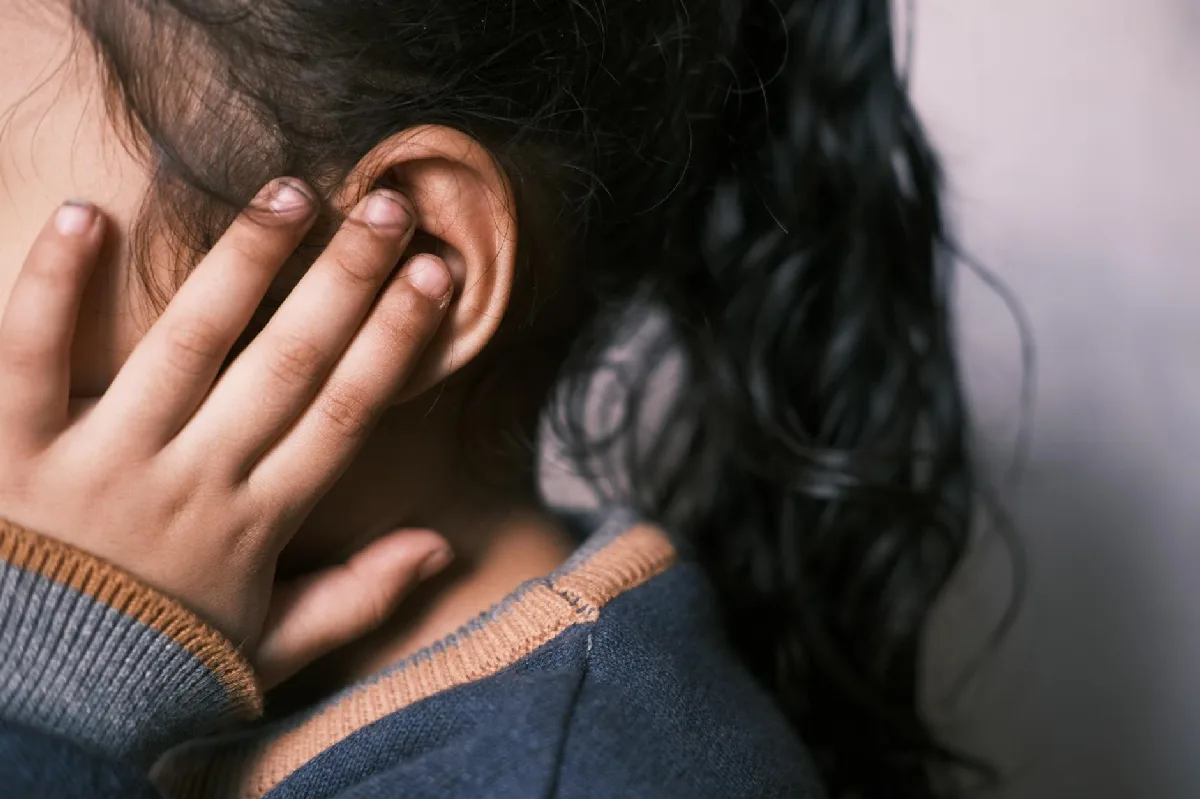 PCA: prazos, NRs e responsabilidades em Curitiba (Gestão) Garota jovem de cabelo escuro cobre a orelha em pose pensativa. — Medicina Ocupacional Curitiba