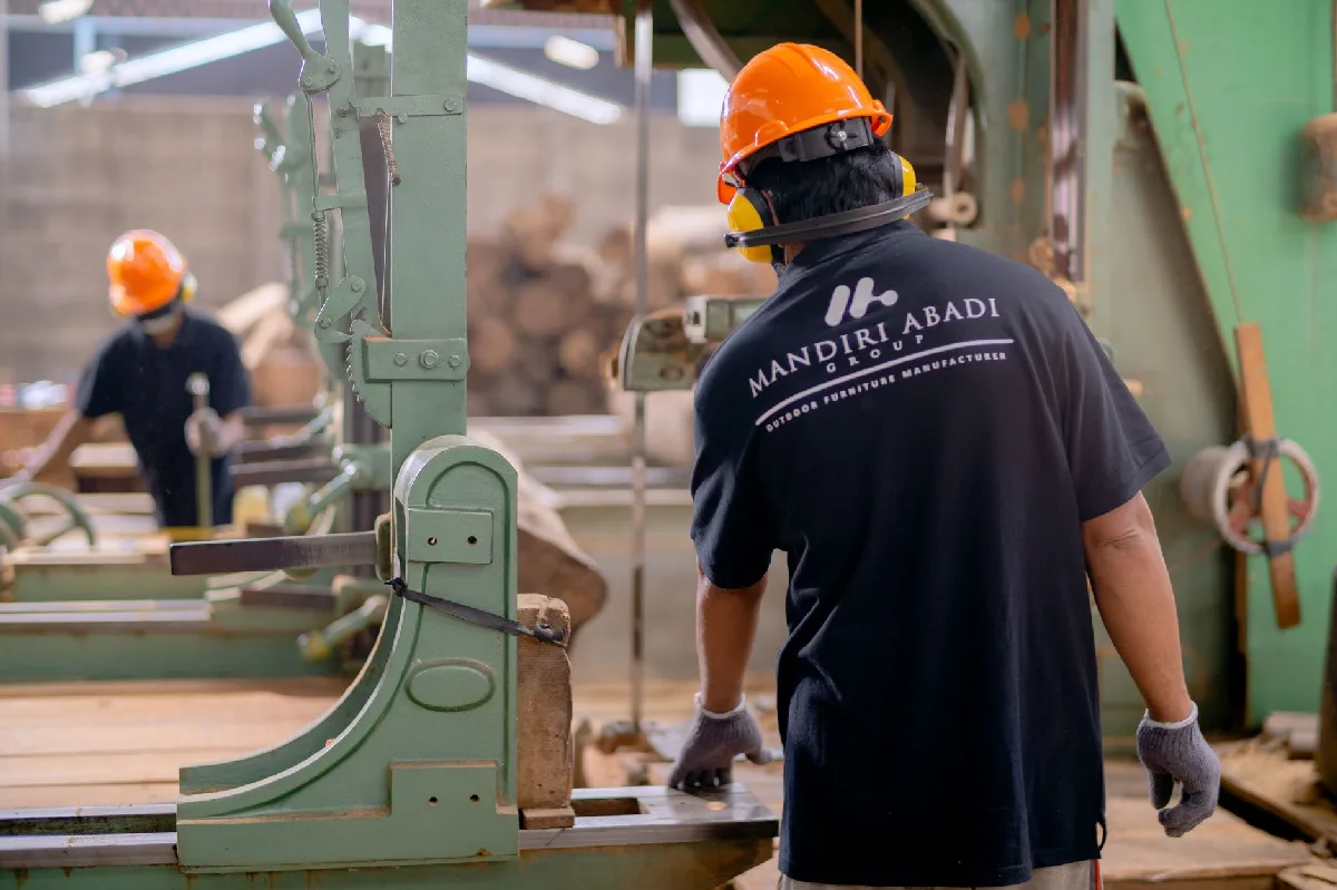 Trabalhadores de EPI operam máquinas em fábrica, focando em segurança e produção. — Medicina Ocupacional Curitiba