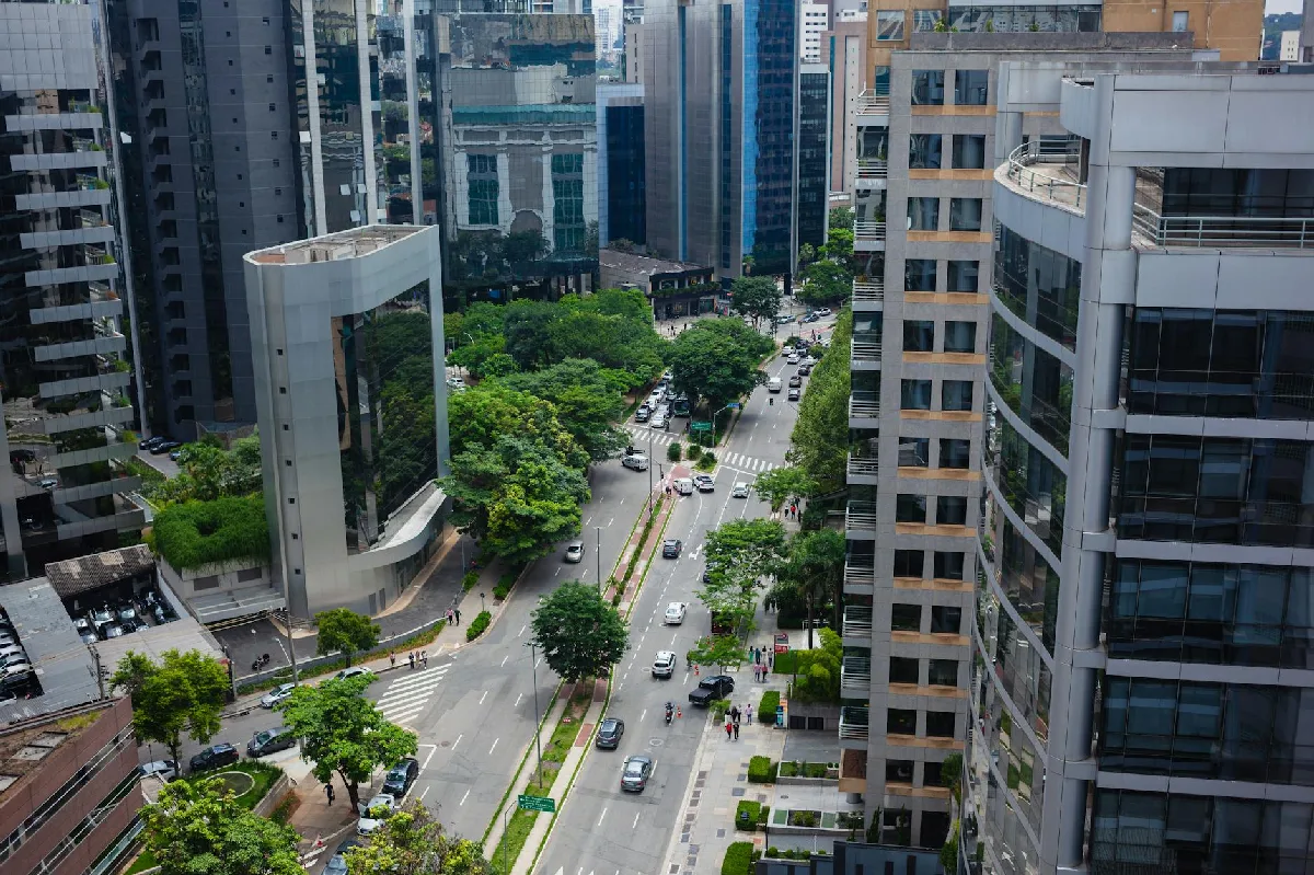 Saneamento de Pendências eSocial em Curitiba: Regularização SST Homem sorri e aponta para um documento em uma mesa com notebook e caneta. — Medicina Ocupacional Curitiba