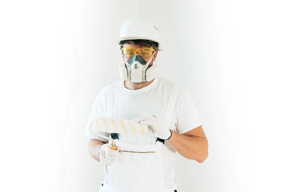 Seleção de Respirador NR-06 em Curitiba: Critérios Técnicos Pintor com equipamento de segurança segura rolo de pintura pronto para trabalhar. — Medicina Ocupacional Curitiba