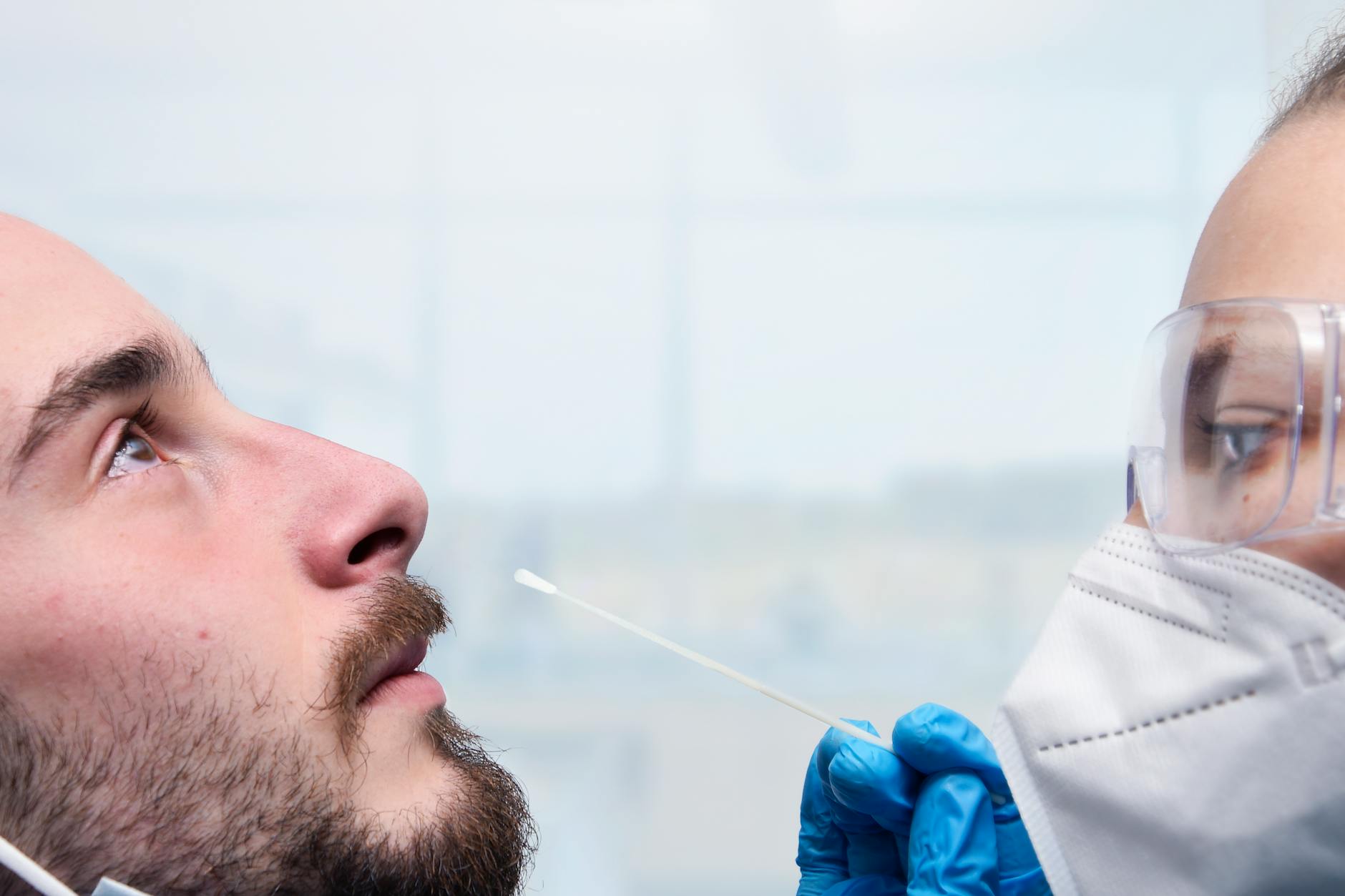 Homem com máscara de proteção facial em teste de vedação, em ambiente de laboratório. — Medicina Ocupacional Curitiba